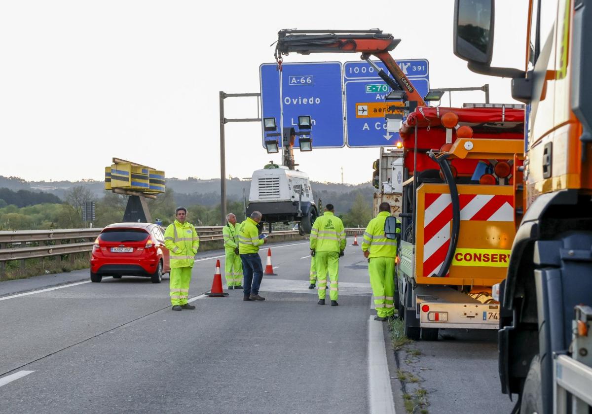 Operarios de conservación descargando la maquinaria, tras cortar el carril deteriorado en la calzada de sentido hacia Oviedo y Avilés.