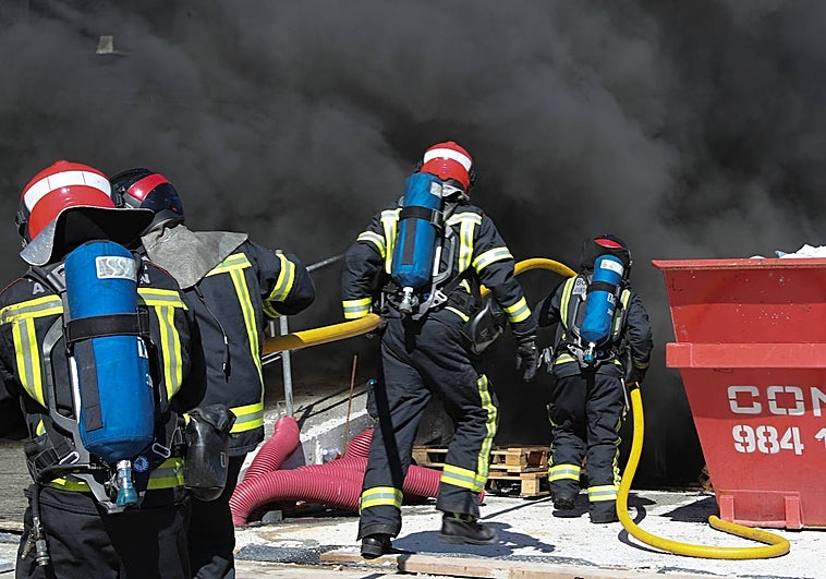 Bomberos sofocando el incendio.