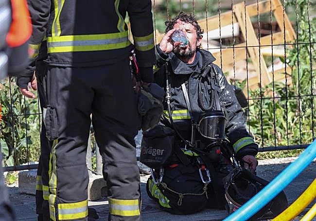 Un bombero, agotado, tras las labores de extinción.