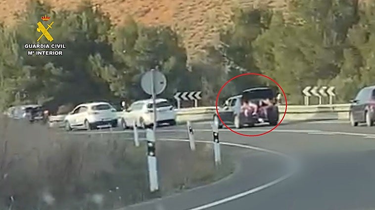 Dos personas, en el maletero del vehículo.