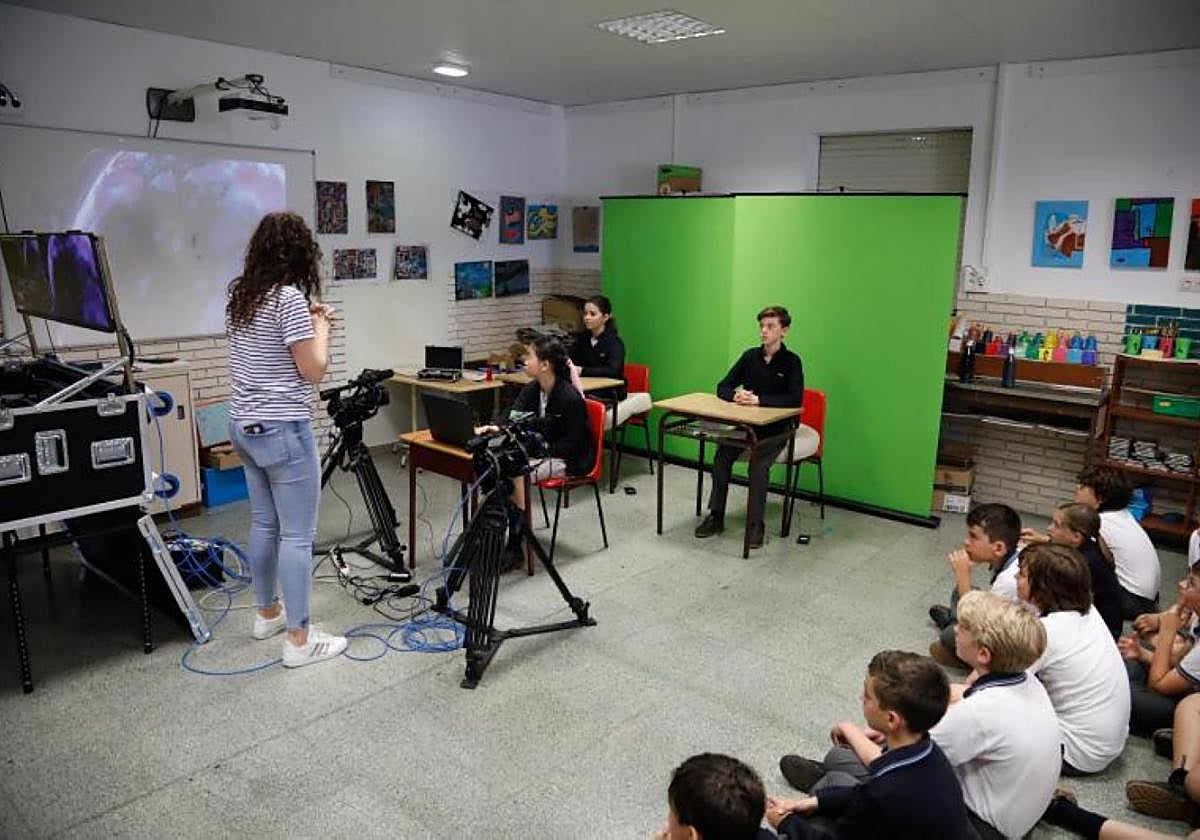 Carmen Muñiz, de EL COMERCIO, da instrucciones antes de comenzar a grabar a los dos presentadores situados ante el croma, Enzo Hevia e Inés López, y a la apuntadora, Lucía Ye, a cargo del teleprómter.