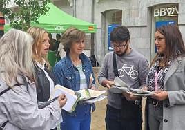 López (a la derecha) entrega propaganda en Avilés.