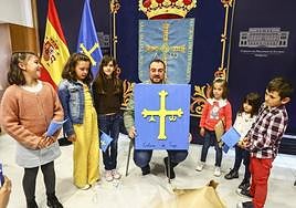 Varios alumnos del Colegio Público Regino Menéndez Antuña posan junto a Adrián Barbón con un lienzo de la bandera de Asturias
