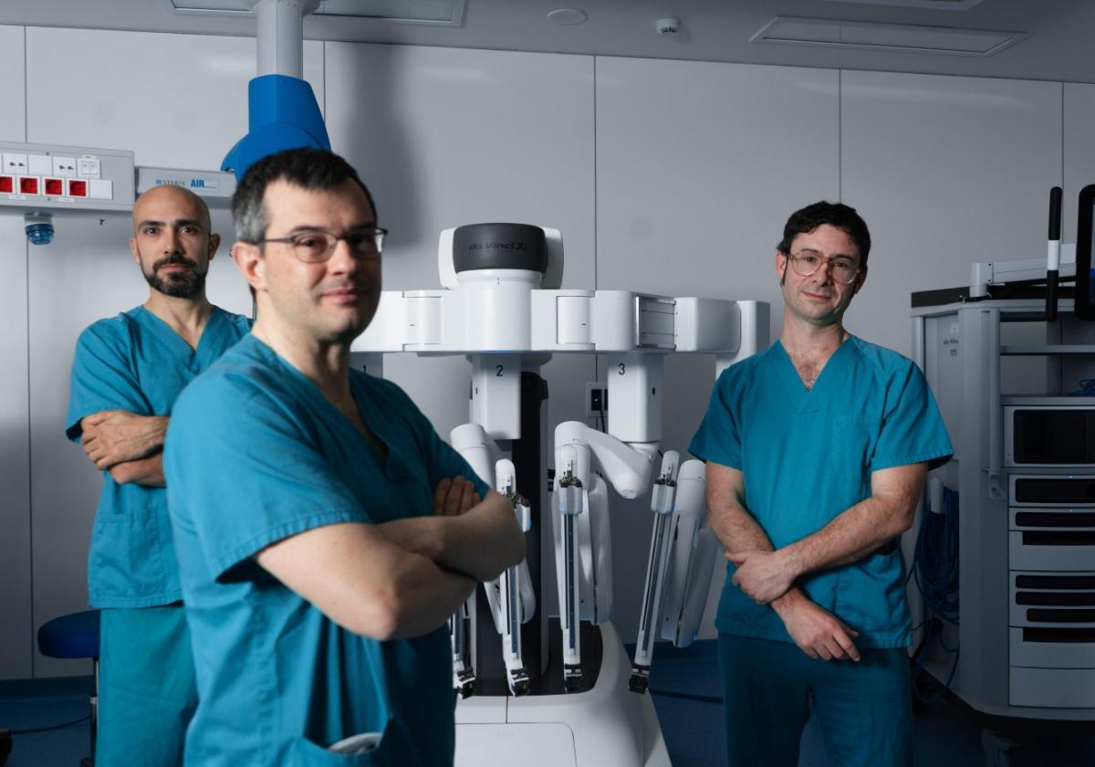 Rodrigo Gil, Guillermo Cruceyra e Iván González, en el Hospital de Jove, junto a los 'brazos' del Da Vinci Xi.