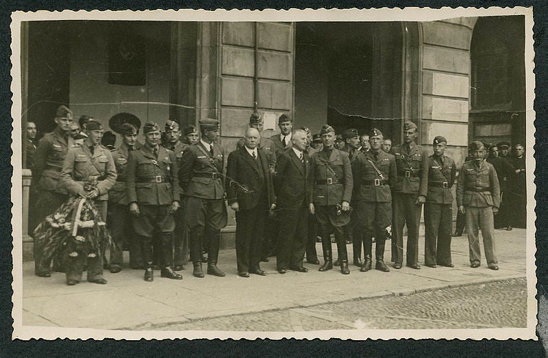 Descubrimiento de una placa en la plaza Mayor en memoria del aviador Willi Senbach, caído en Gijón el 23 de septiembre de 1937. Asistió el cónsul de Alemania en España, Eberhard Von Stohrer, una representación de la Legión Cóndor, a la que pertenecía el piloto, y oficiales del Ejército del Aire. Datada el 21 de octubre de 1938.