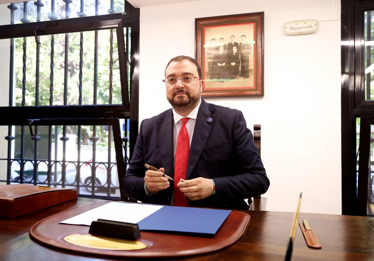 Adrián Barbón, en la sala Belarmino Tomás de Presidencia, firmó el decreto de constitución de la Junta con el bolígrafo artesano que usa para las rúbricas señaladas. Tras él, una foto de la familia de Belarmino Tomás.