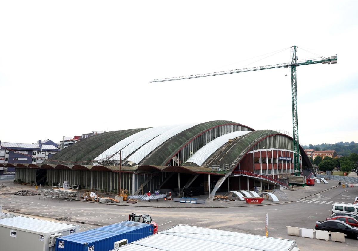 Tres operarios en el exterior del Palacio de los Deportes, cuyas obras se han paralizado desde el viernes.