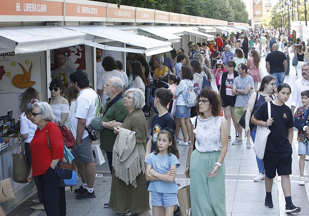 Aluvión de gente en el primer día de la Feria del Libro de Gijón, en el paseo de Begoña.