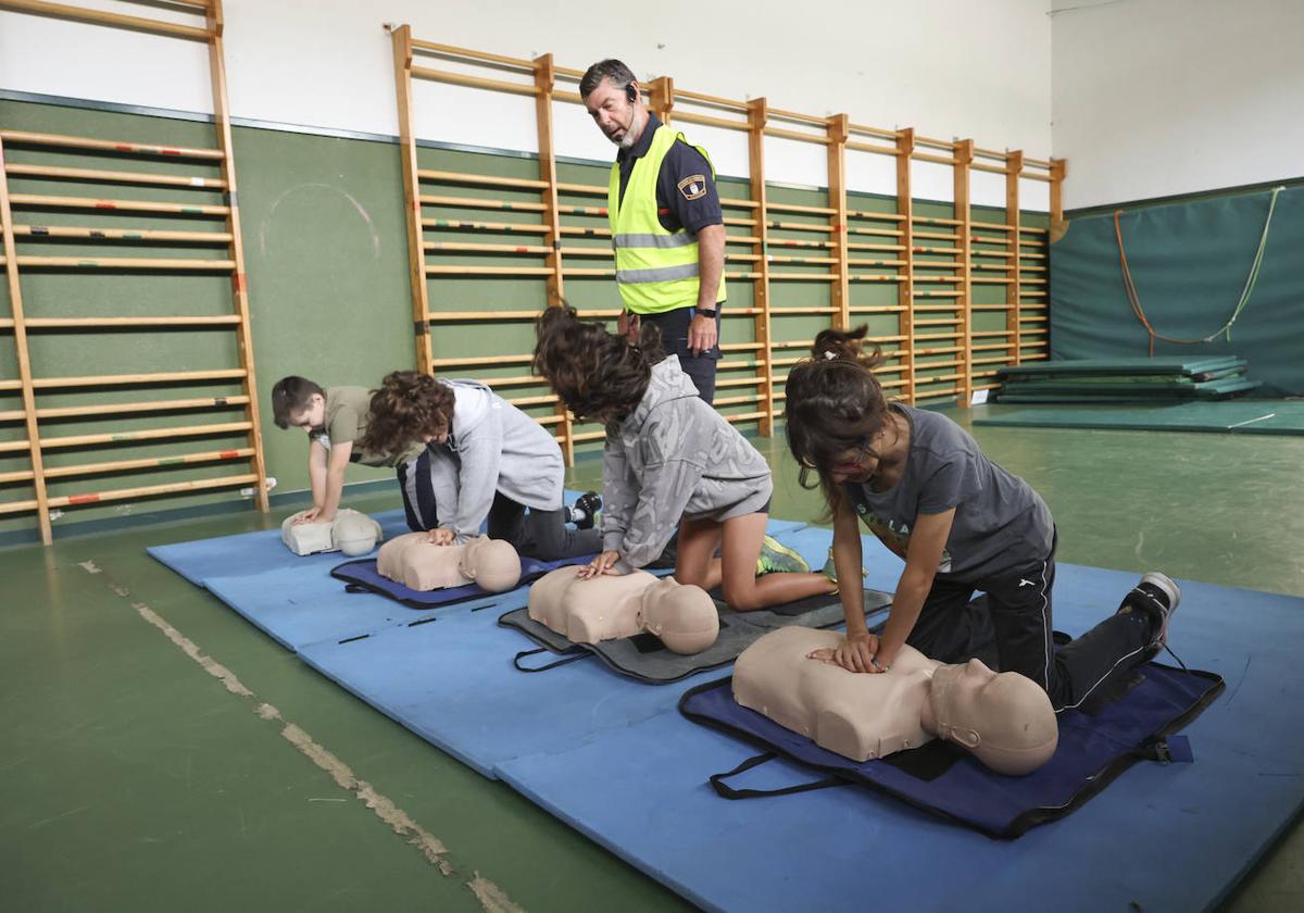 Los alumnos, durante la celebración del taller, practican la reanimación cardiopulmonar.