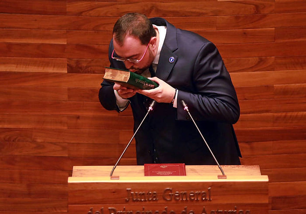 Adrián Barbón besa la Biblia antes de guardarla en un cajón bajo el atril donde prometió el cargo de diputado sobre la Constitución y el Estatuto de Autonomía.
