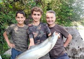 Enol Álvarez, con el mayor salmón de la temporada (9,03 kilos), entre su padre, Marino, y su hermano Omar.