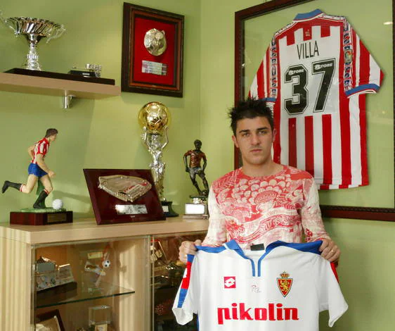David Villa posa con la camiseta del Zaragoza y la del Sporting tras su traspaso.
