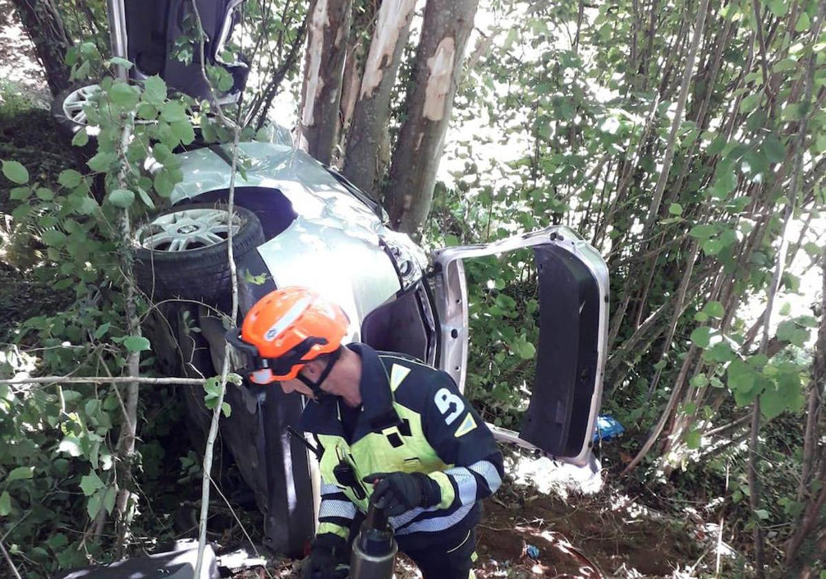 Un bombero del Sepa, frente al coche accidentado.