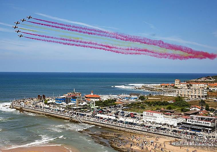 Formación del final de la exhibición de la Patrulla Águila formando con humo los colores de la bandera de España, en la zona derecha de la bahía.
