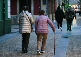 Dos mujeres mayores pasean por las calles de Pola de Siero.