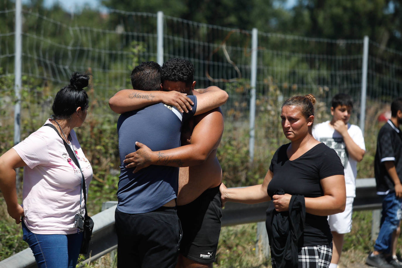 Dos hombres, en presencia de dos mujeres, se abrazan tras abandonar el poblado por precaución.