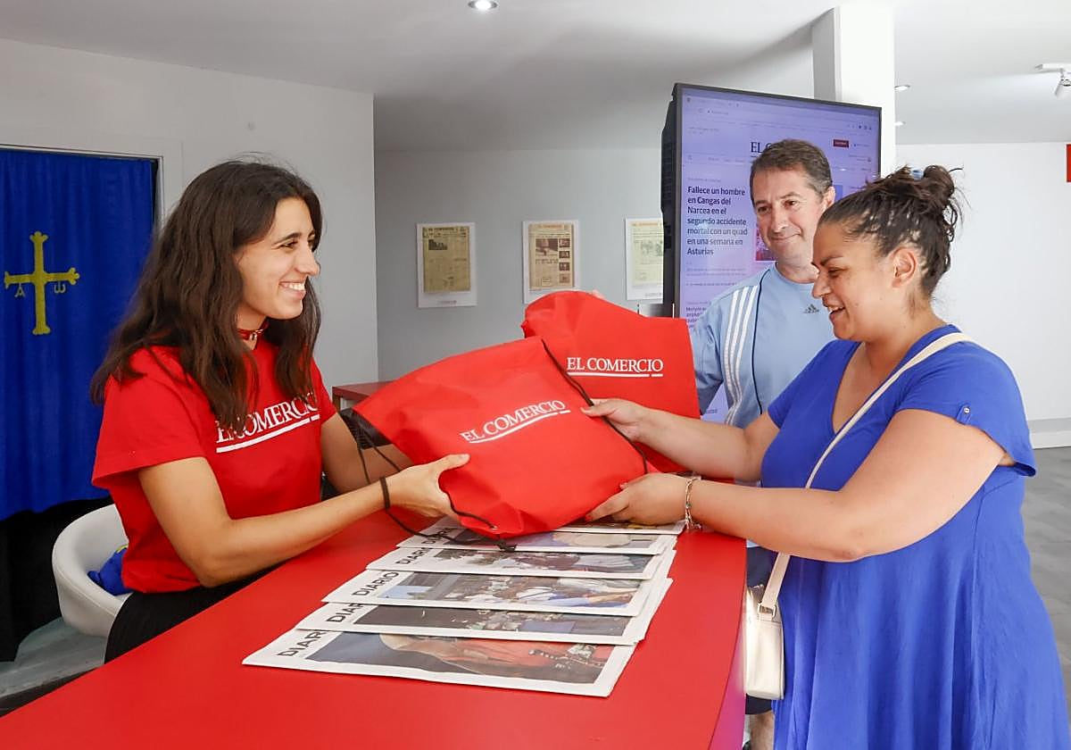 Irene Cervantes entrega la bolsa de EL COMERCIO a Yamena López y Luis Enrique Fernández, asiduos a este periódico: «Todas las mañanas leemos el digital». Gracias a la bolsa de la Feria tienen un mes de suscripción gratuita, una cantimplora con el logo del periódico y numerosos regalos.