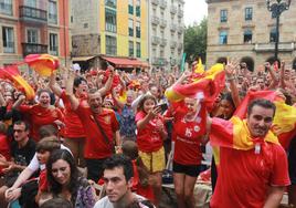 Los aficionados reunidos en la Plaza Mayor de Gijón celebran la victoria de España.