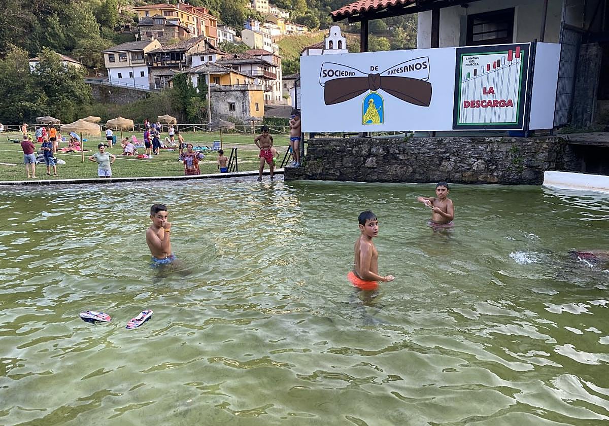 Un grupo de niños se baña en la Presa del Prao del Molín, en Cangas del Narcea, mientras el resto juega en el prao.