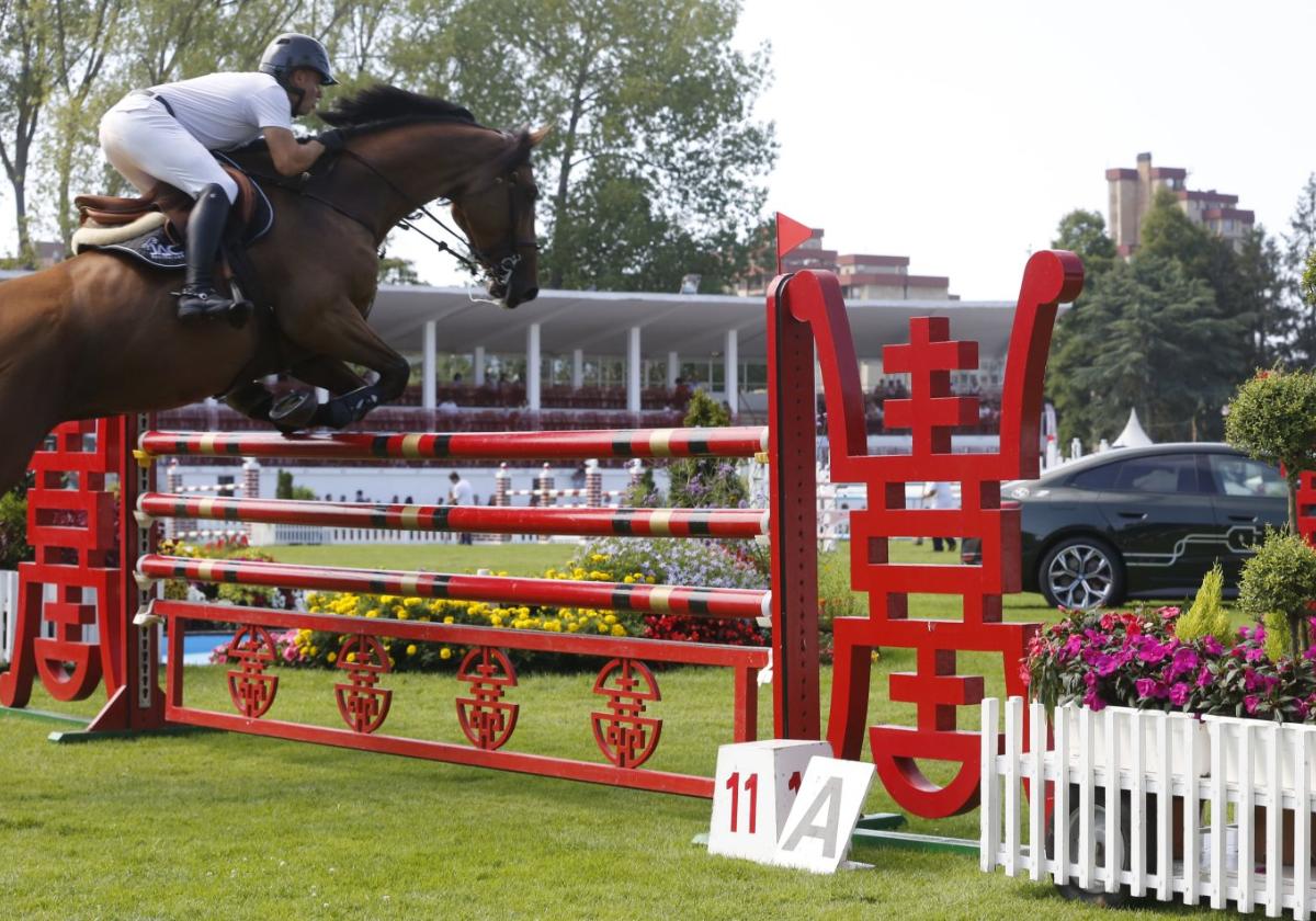 Un jinete supera con su caballo el obstáculo de las letras chinas y los de las columnas de ladrillo al fondo.