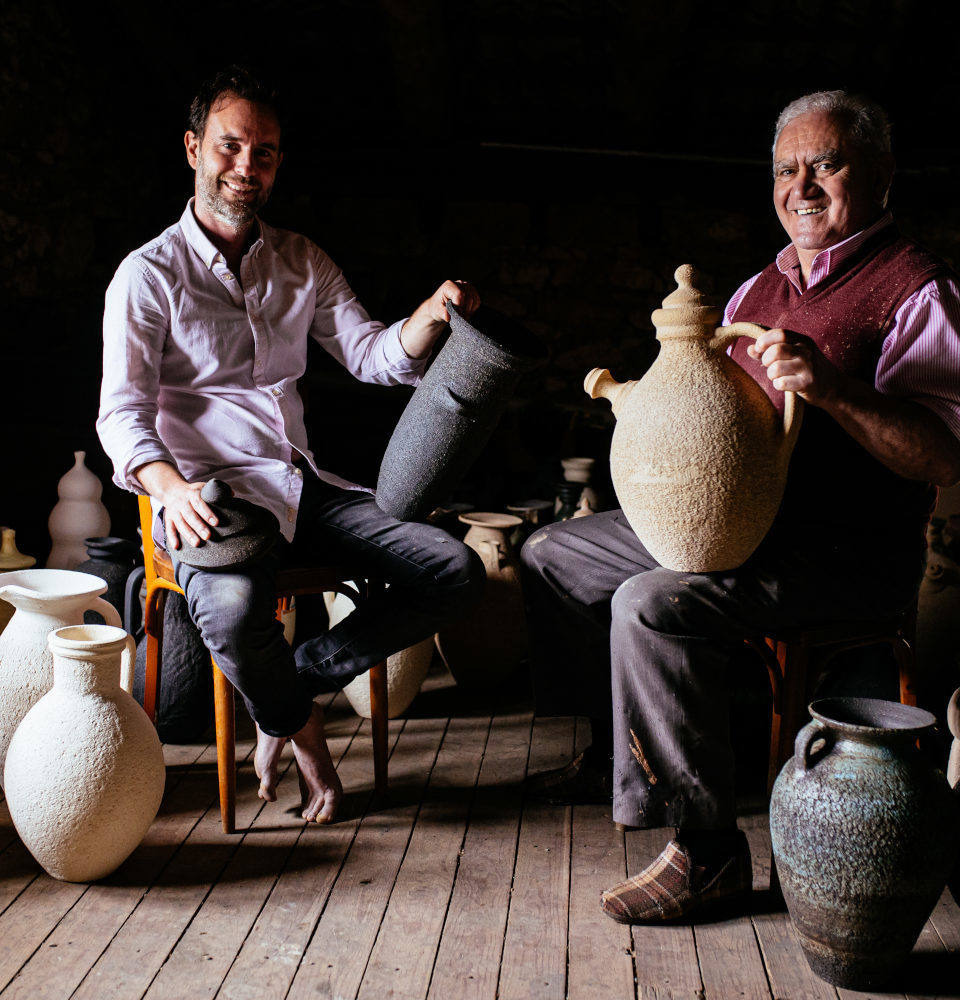 El artista Raúl Mouro junto a su padre, el alfarero Marcelino Rodríguez, rodeados de sus piezas de cerámica.