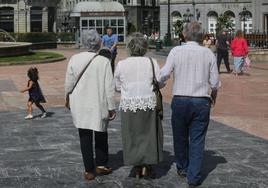 Tres personas mayores pasan junto a una niña en la plaza de la Escandalera, en Oviedo.