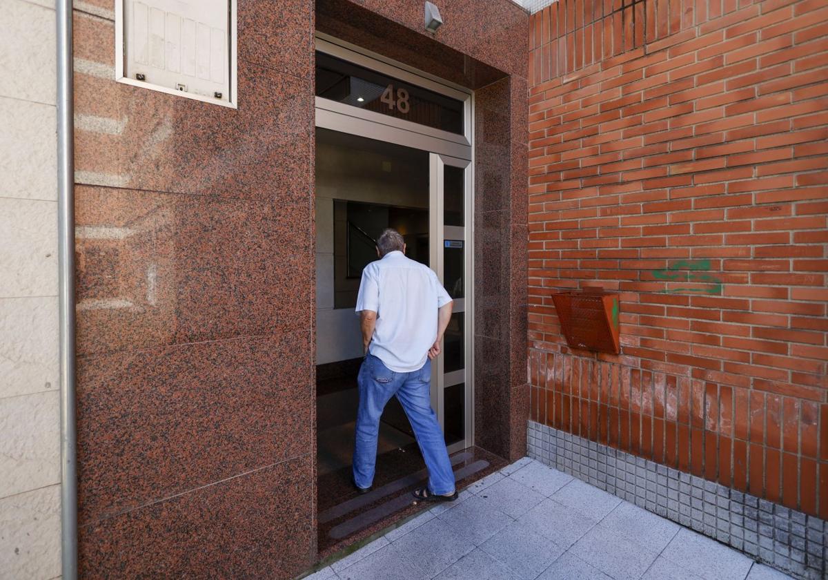 Un vecino entra en el edificio de Contrueces en el que vive Felipe A. R. en un piso compartido.