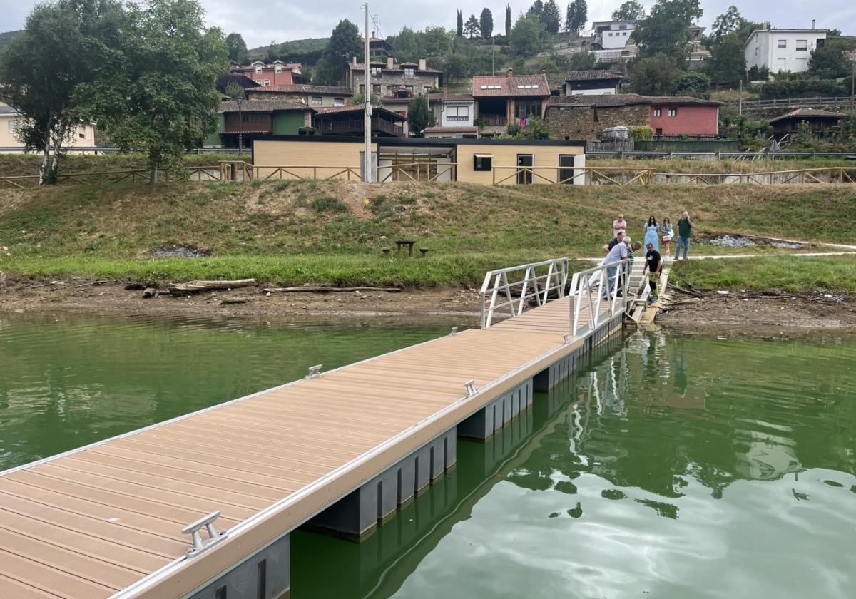 El embarcadero para el uso lúdico en el pantano de Tanes, Caso, con los almacenes al fondo.