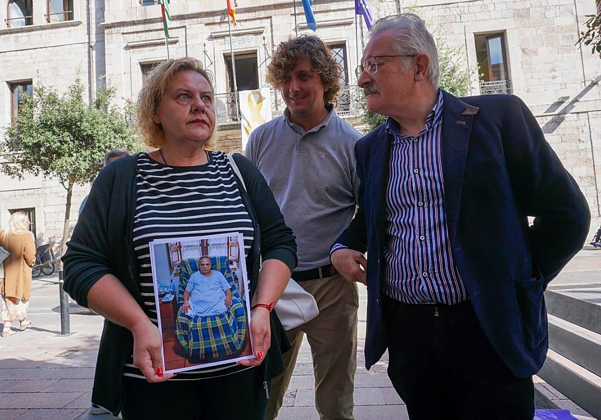 Sofía Noriega sostiene una foto de su madre, acompañada por los socialistas Luis Arenas y Antonio Trevín.