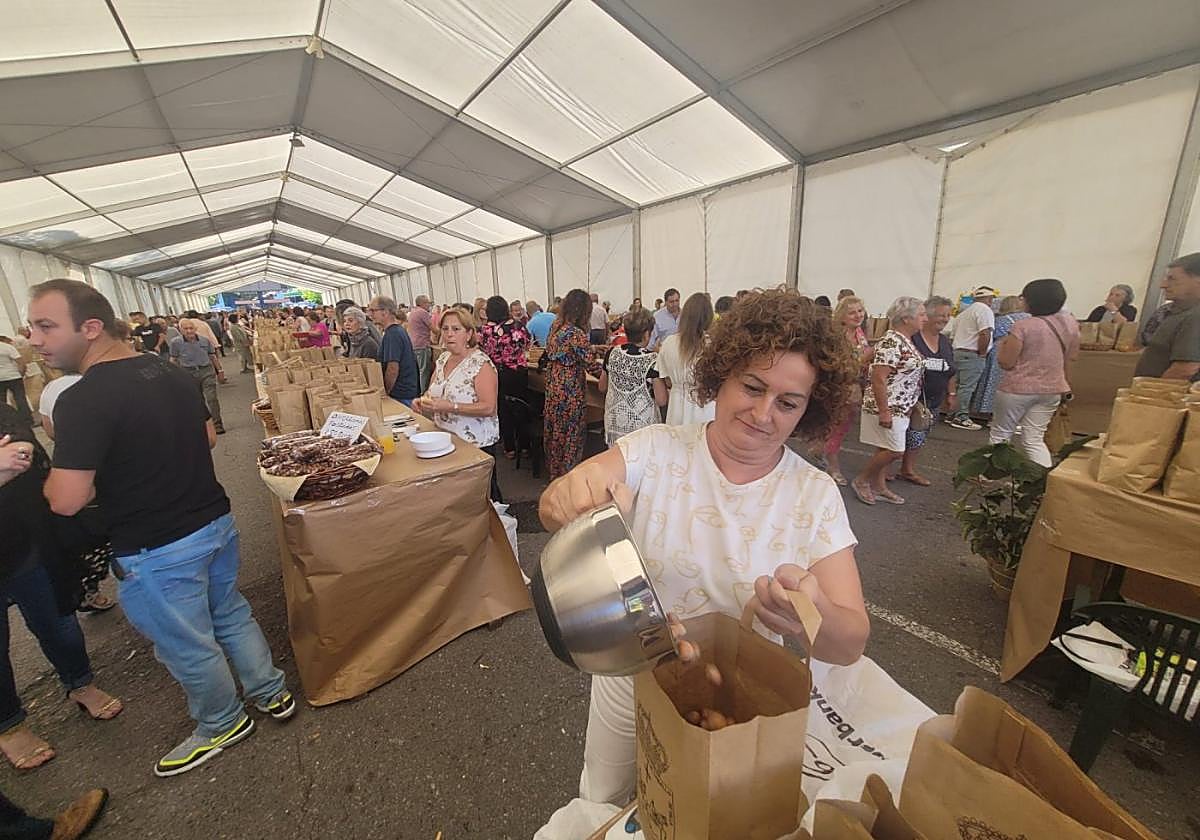 Ana Isabel Fernández, de la Matosa, echa avellanas en una bolsa para su venta.
