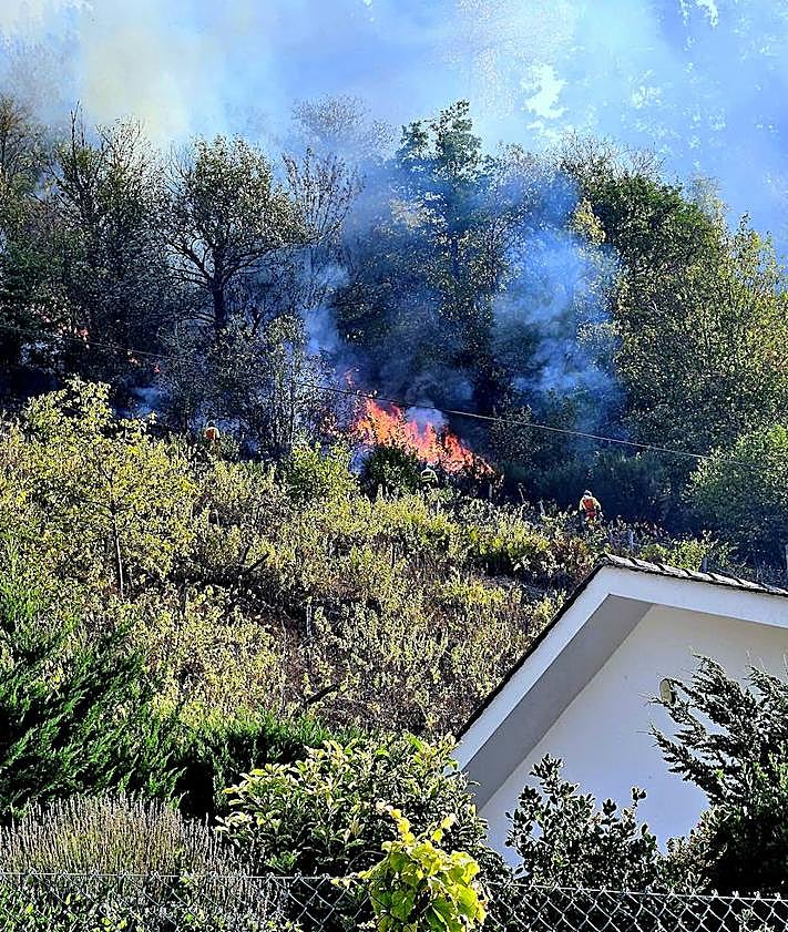 Imagen secundaria 2 - Vecinos y efectivos en la zona se esfuerzan por controlar el avance de las llamas.