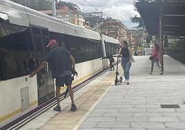 Varios usuarios de la línea de tren Gijón-Laviana, ayer, en la estación de Sotrondio.