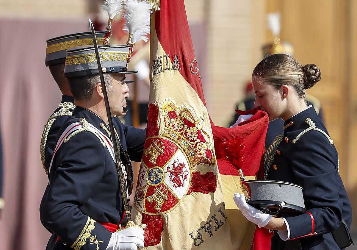 La Princesa, jurando bandera en Zaragoza el pasado 7 de octubre. En la página siguiente, de naranja, en una reunión de jóvenes en Girona, acto al que acudió ya sin sus padres y junto a su hermana.