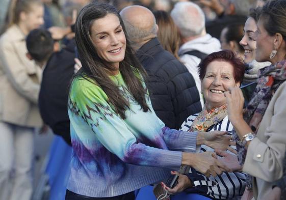 La Reina Letizia saluda a algunas vecinas en su visita a las parroquias de Arroes, Peón y Candanal.