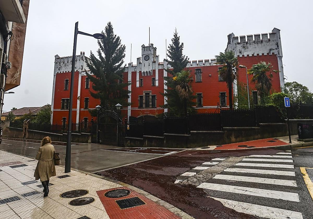 Una mujer pasea por la calle Marcelino Fernández, frente a la entrada principal de la fábrica de armas de La Vega.