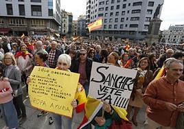 La protesta en la plaza del Marqués de Gijón también fue multitudinaria. En primer plano, dos mujeres con pancartas.