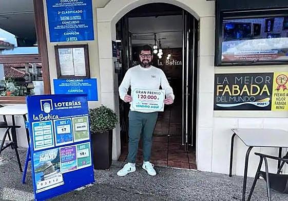 Otto Gutiérrez, del despacho mixto de lotería de Lastres, con el diploma acreditativo del premio.