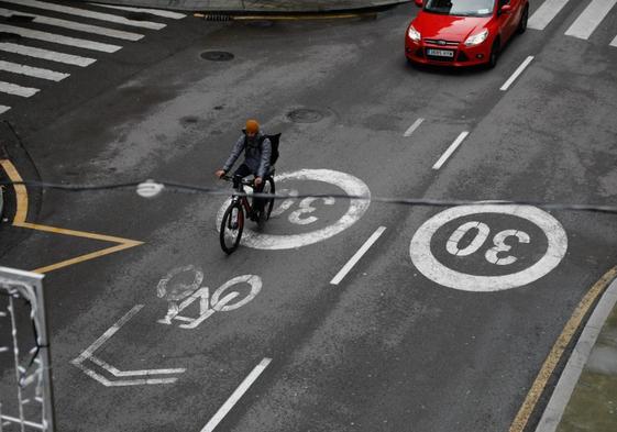 Un ciclista circula por el ciclocarril de Marqués de San Esteban, parcialmente desgastado.