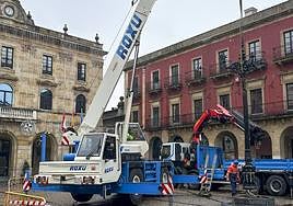 Una grúa retira la farola central de la plaza Mayor.