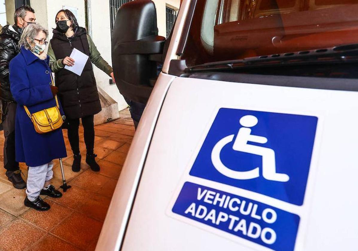 Usuarios y familiares del Centro de Día El Naranco ante uno de los microbuses contratados por el ERA para su traslado, durante el anterior suspenso del servicio.