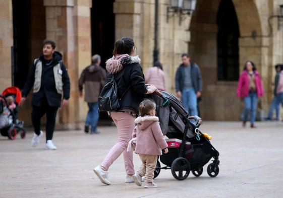 Una madre con su hijos pasea por el centro de Oviedo.