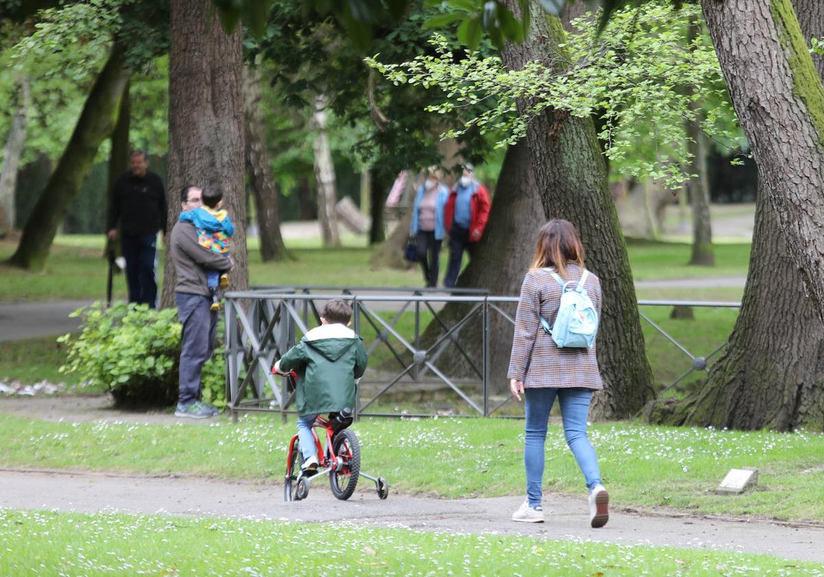 Una familia pasea con sus hijos por un parque de Avilés.