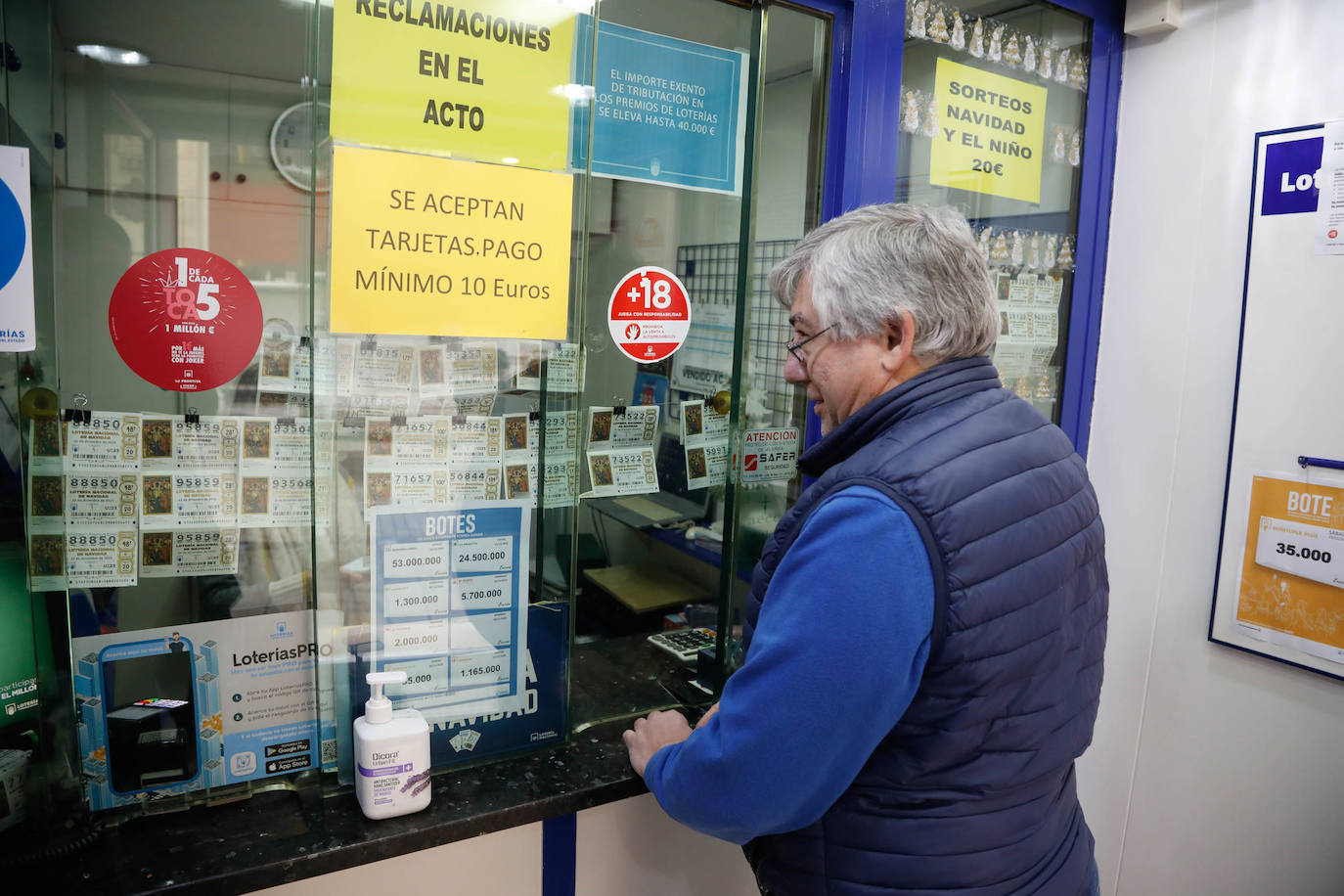 Un hombre compra lotería en una administración de Avilés.