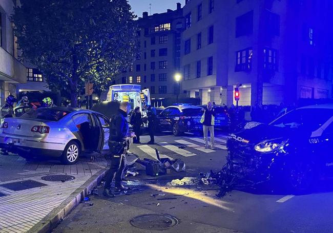 Espectacular choque entre un coche de la Policía y un turismo en Gijón.