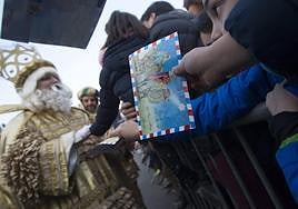 Un niño le da su carta al rey Melchor.
