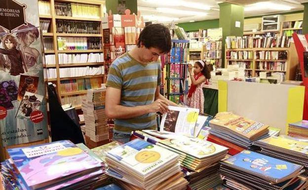 Un joven consulta unos libros en una biblioteca de Granada 