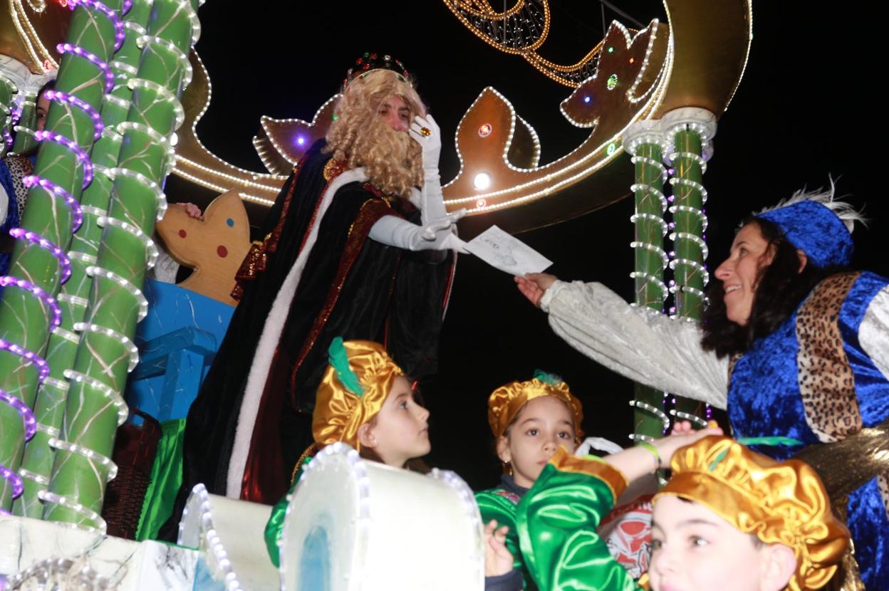 El rey Gaspar recoge una carta de última hora de uno de los niños asistentes a la cabalgata que recorrió las calles de Mieres. 