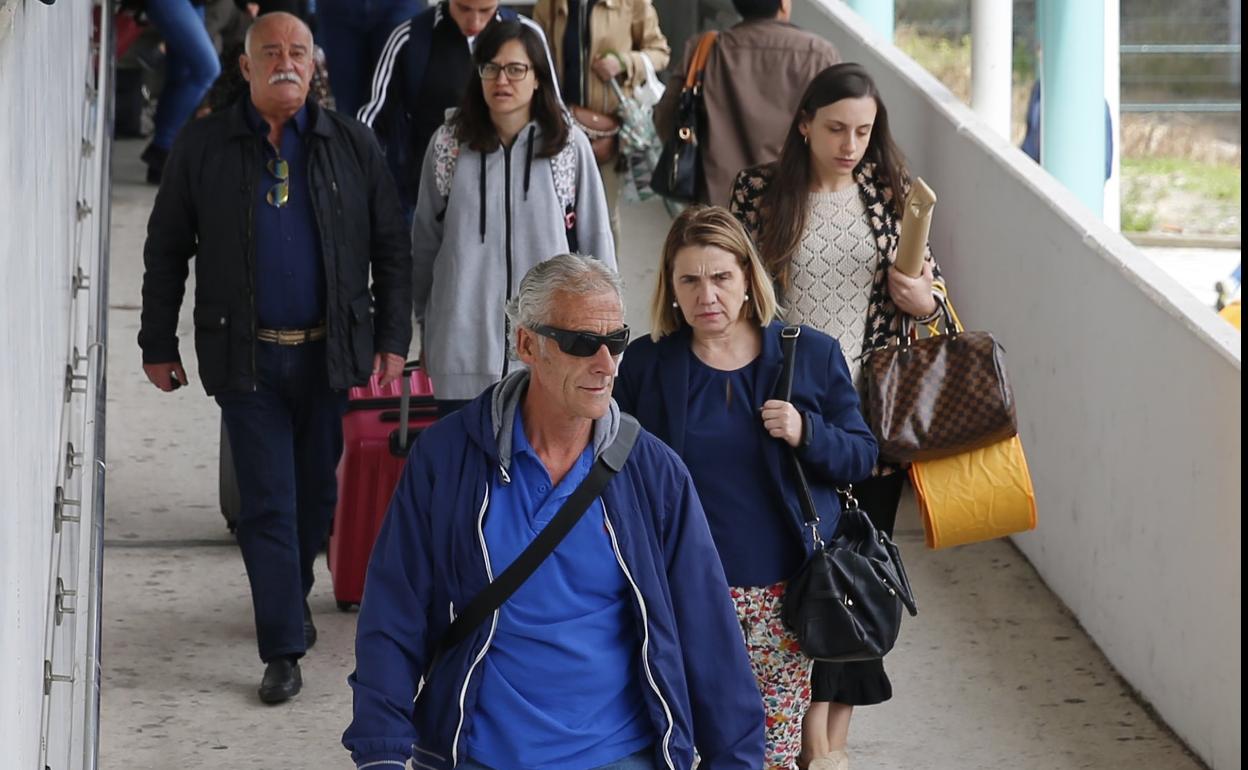 Varios turistas salen de la estación provisional de tren de Gijón. 