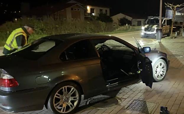 Un guardia civil inspecciona el coche implicado en el accidente.
