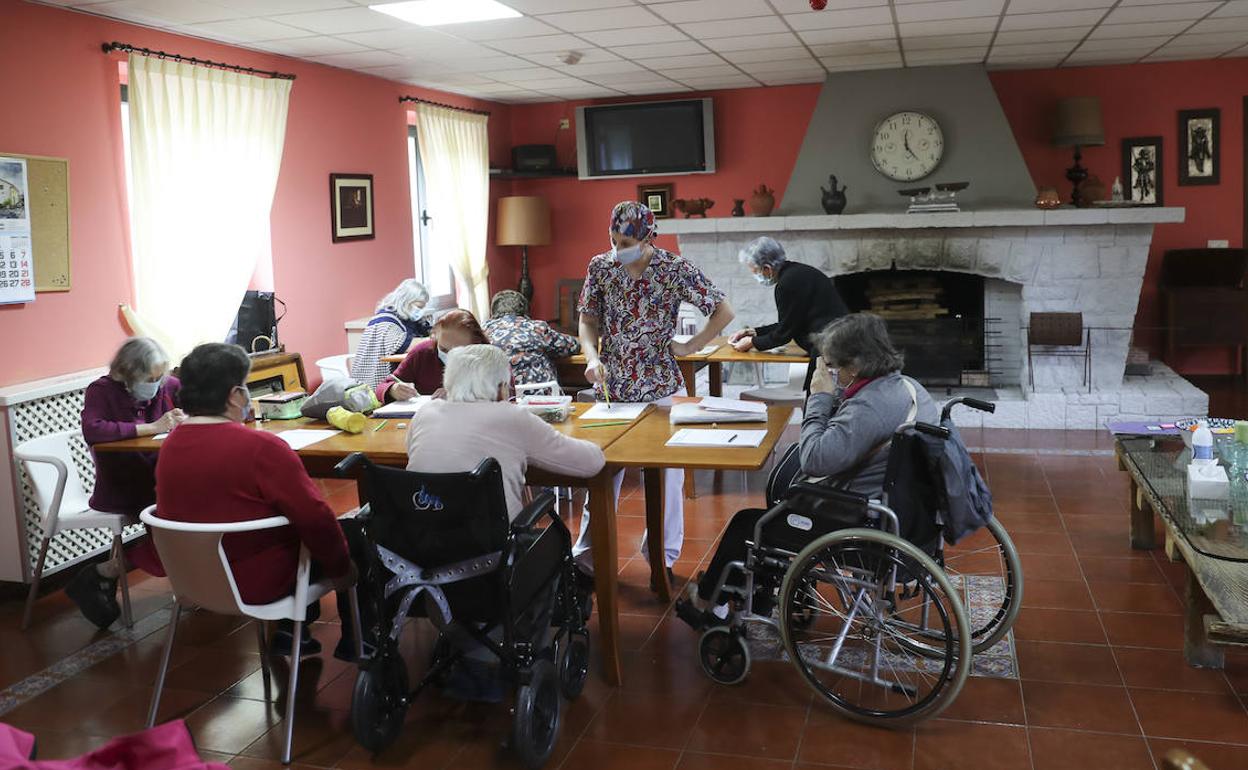 Un grupo de residentes realiza tareas en el salón de la residencia Nuestra Señora del Amparo. 